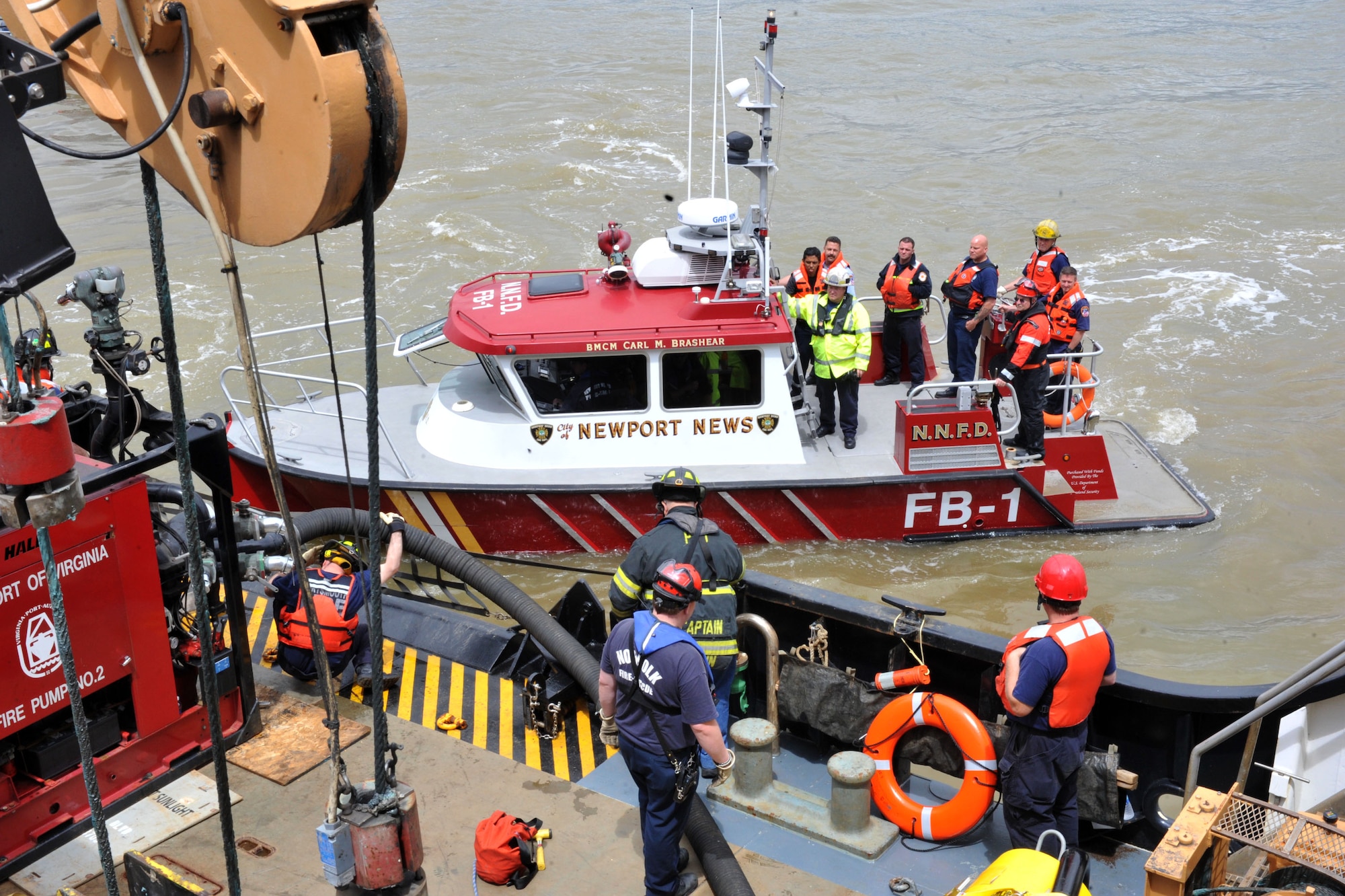 Firefighters from the Newport News Fire Department and students from the Hampton Roads Marine Firefighting School participate in a maritime incident response exercise at Fort Eustis, Va., May 16, 2014. The exercise was the culmination of hands-on and practical training during the five-day school, which started May 12, 2014.  (U.S. Air Force photo by Staff Sgt. Katie Gar Ward/Released)