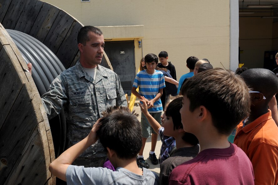 Staff Sgt. Nathan Munford, 39th Communications Squadron cable/antenna maintenance supervisor, gives Incirlik Unit School students a tour of the cable maintenance area during Job Shadow Day May 16, 2014, Incirlik Air Base, Turkey. During Job Shadow Day, students toured several base agencies before going to work centers individually to shadow someone at work. (U.S. Air Force photo by Tech. Sgt. Dallas Edwards/Released)