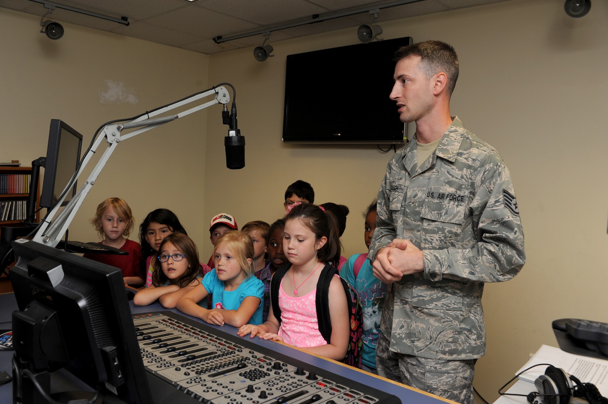 Staff Sgt. Brad Kasch, American Forces Network-Incirlik broadcaster, gives Incirlik Unit School students a tour of the radio studio during Job Shadow Day May 16, 2014, Incirlik Air Base, Turkey. The day consisted of a base tour followed by shadowing someone in a work center. (U.S. Air Force photo by Tech. Sgt. Dallas Edwards/Released)