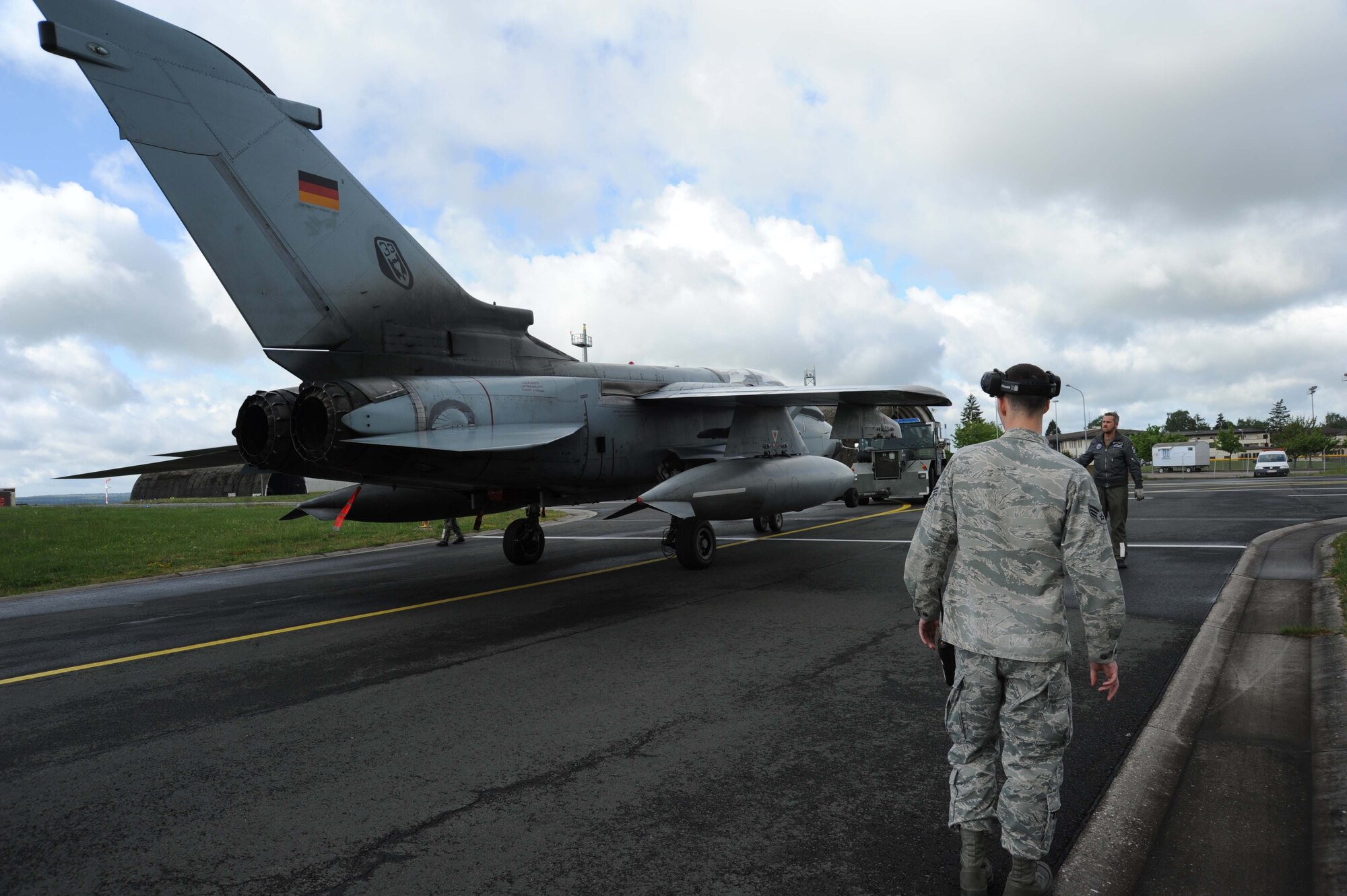 A U.S. Air Force Airman oversees the parking of a German air force PA-200 Tornado multirole combat aircraft May 7, 2014, at Spangdahlem Air Base, Germany. The tornado is an all-weather multi-role combat aircraft with a variable-sweep wing. (U.S. Air Force photo by Airman 1st Class Dylan Nuckolls/Released)