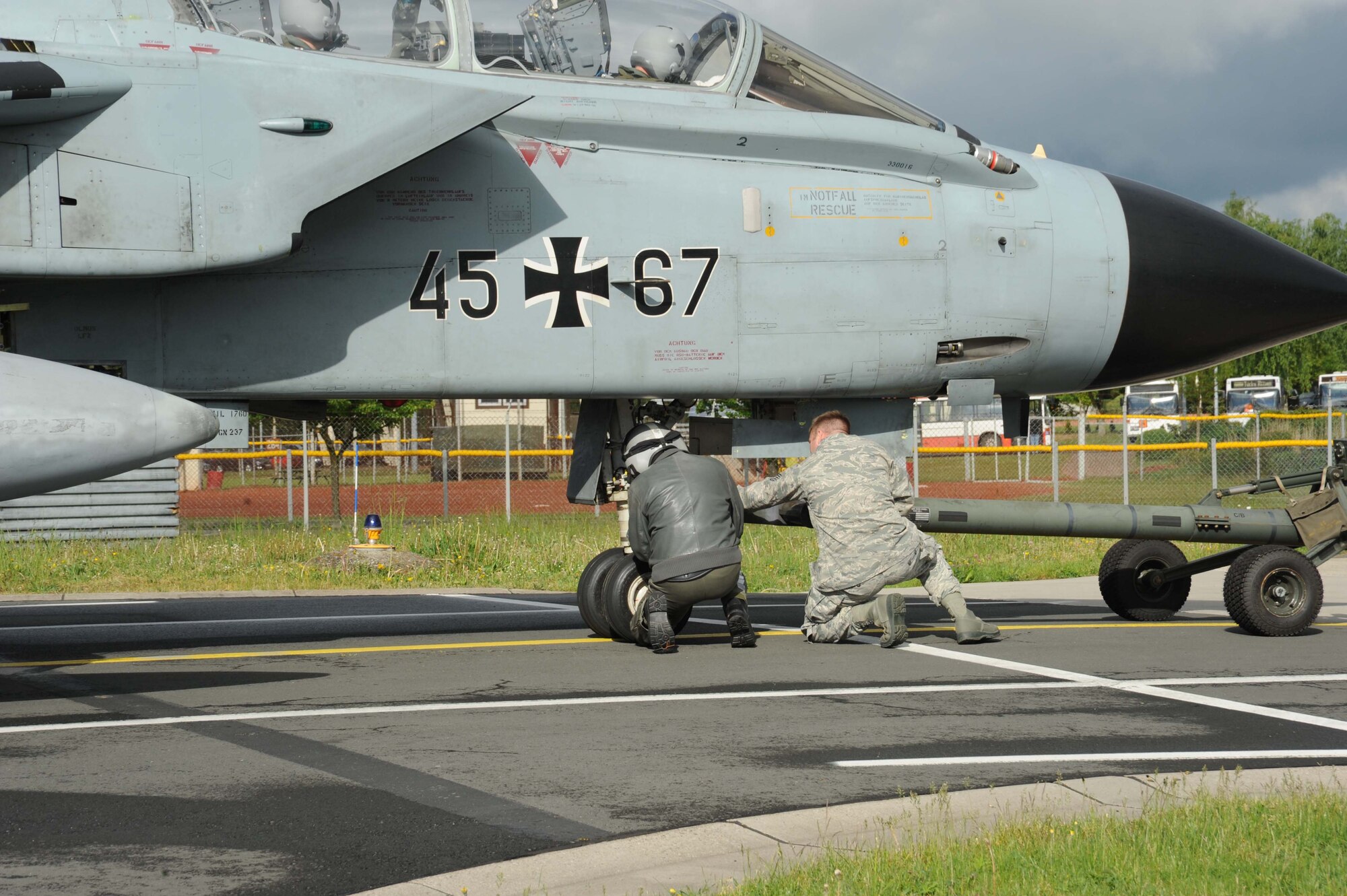 A member of the German air force and a U.S. Air Force Airman work to connect equipment to a German air force PA-200 Tornado multirole combat aircraft in preparation to move the aircraft May 7, 2014, at Spangdahlem Air Base, Germany.  The tornado stopped here for a safety test. (U.S. Air Force photo by Airman 1st Class Dylan Nuckolls/Released)