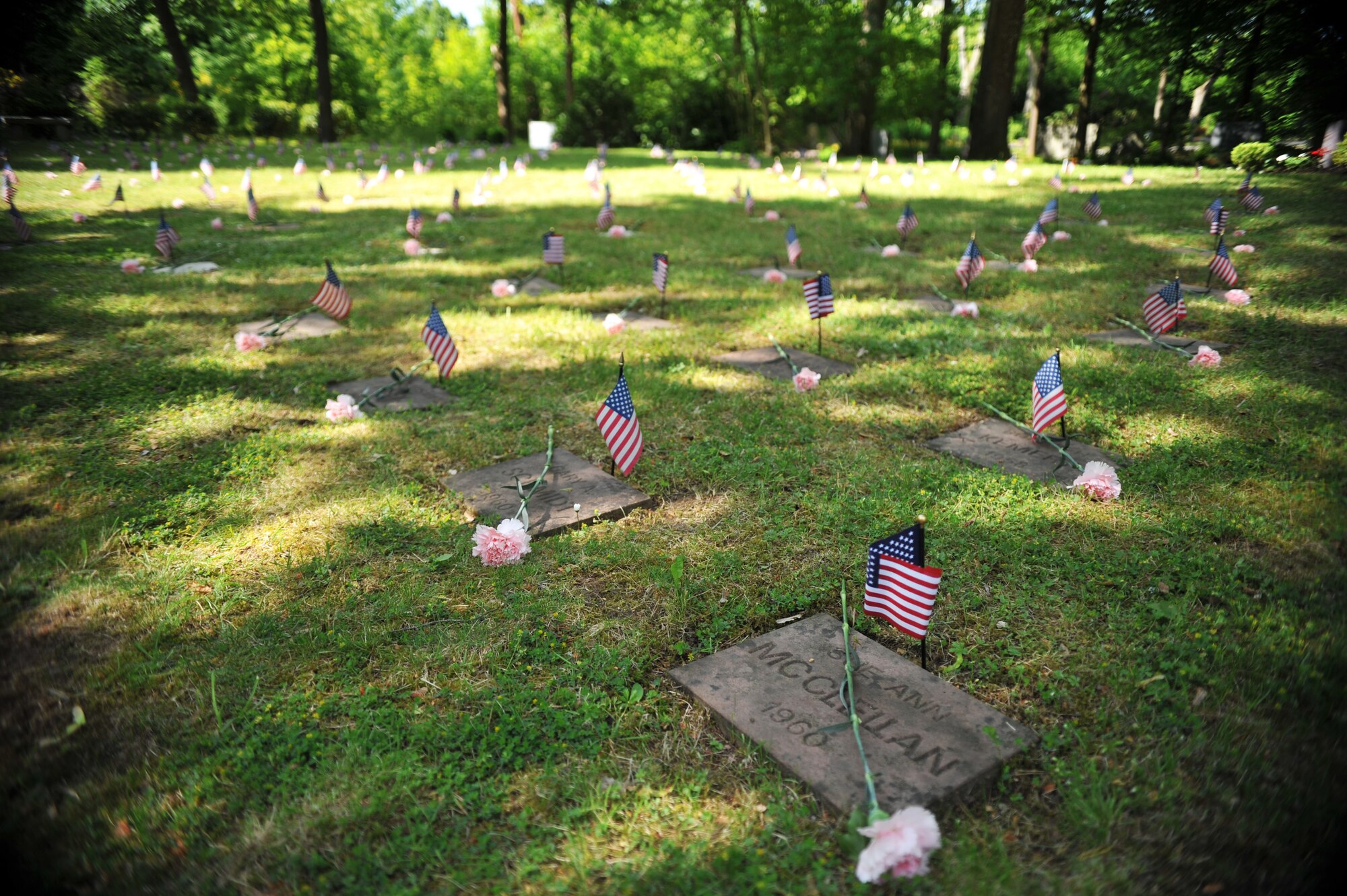The final resting places for 451 American children of service members stationed in Europe during the buildup of the Cold War, were decorated with an American flag and rose before the Kindergrave’s memorial ceremony at the Kaiserslautern cemetery, Germany, May 17, 2014. A ceremony is held every year the Saturday after Mother’s Day to keep the children’s memories alive. (U.S. Air Force photo/Senior Airman Hailey Haux) 