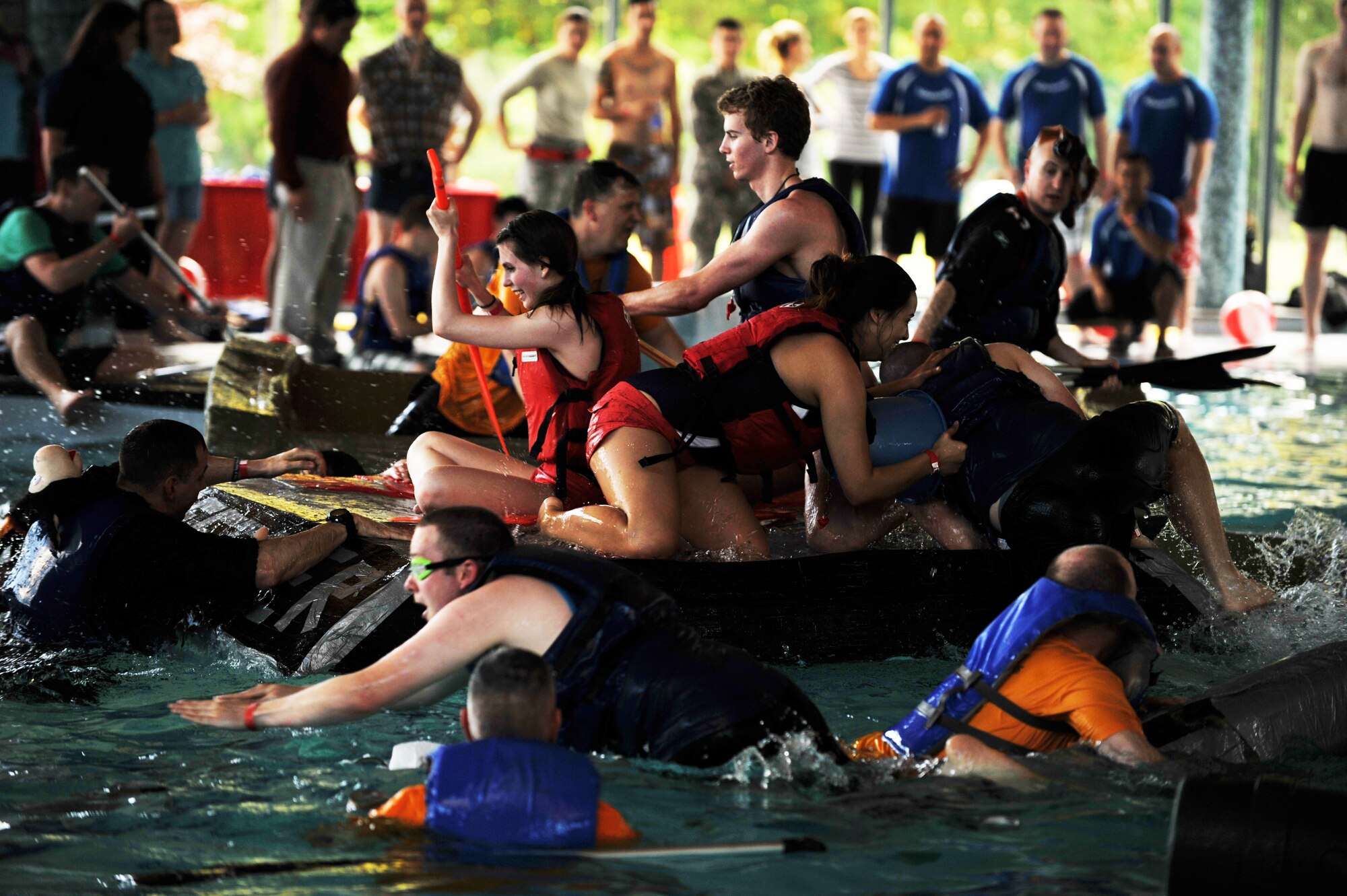 Battle of the Battleships participants go through the challenge round where the last boat left floating wins at the base aquatic center on Ramstein Air Base, Germany, May 16, 2014. Battle of the Battleships is an annual competition hosted by the 86th Force Support Squadron in which teams construct boats out of cardboard and duct tape, then race them to and from the other end of the pool. (U.S. Air Force photo/Senior Airman Hailey Haux)