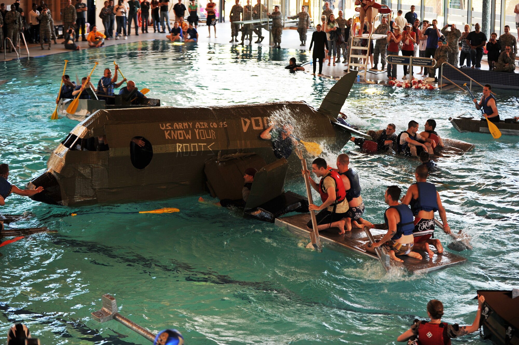 Battle of the Battleships participants go through the challenge round where the last boat left floating wins at the base aquatic center on Ramstein Air Base, Germany, May 16, 2014. Battle of the Battleships is an annual competition hosted by the 86th Force Support Squadron in which teams construct boats out of cardboard and duct tape, then race them to and from the other end of the pool. (U.S. Air Force photo/Senior Airman Hailey Haux)
