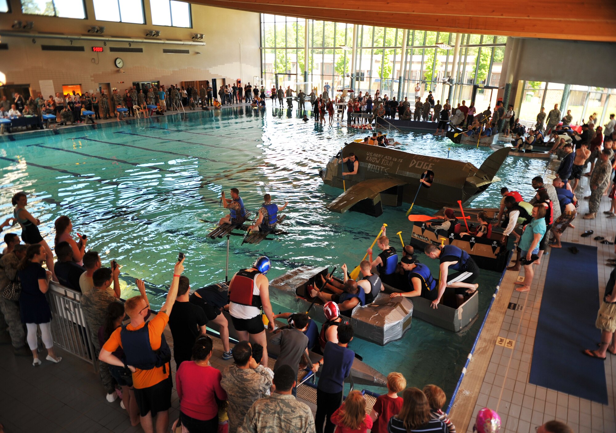 Battle of the Battleships participants go through the challenge round where the last boat left floating wins at the base aquatic center on Ramstein Air Base, Germany, May 16, 2014. Battle of the Battleships is an annual competition hosted by the 86th Force Support Squadron in which teams construct boats out of cardboard and duct tape, then race them to and from the other end of the pool. (U.S. Air Force photo/Senior Airman Hailey Haux)