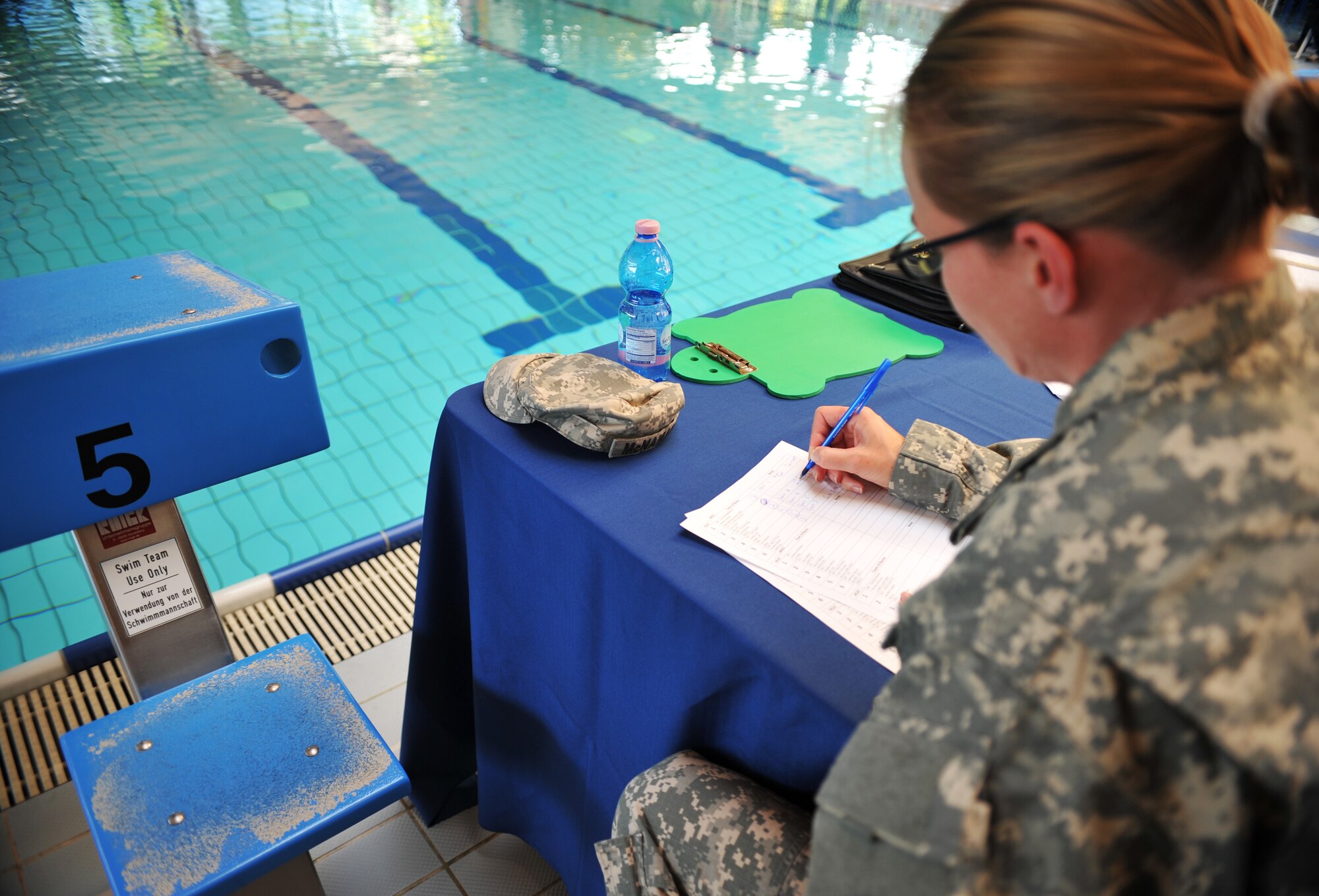 A Battle of the Battleships judge takes notes after one heat of races is over at the base aquatic center on Ramstein Air Base, Germany, May 16, 2014. Battle of the Battleships is an annual competition hosted by the 86th Force Support Squadron in which teams construct boats out of cardboard and duct tape, then race them to and from the other end of the pool. (U.S. Air Force photo/Senior Airman Hailey Haux)