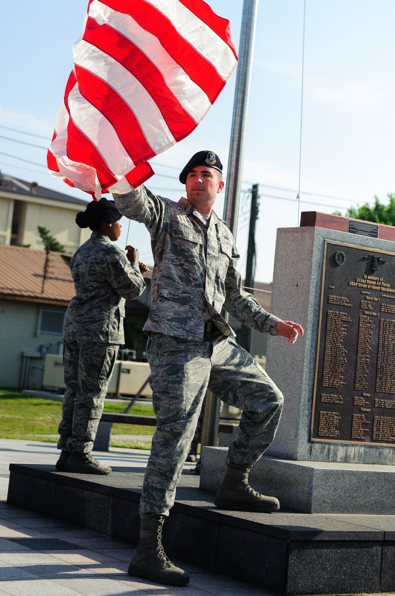 Staff Sgt. Brent Kimbell, 8th Security Forces Squadron member, catches the flag during a retreat ceremony at Kunsan Air Base, Republic of Korea, May 15, 2014. The 8th SFS honored 22 fallen defenders, office of special investigations agents and military working dogs as part of National Police Week. (U.S. Air Force photo by Senior Airman Armando A. Schwier-Morales/Released)
