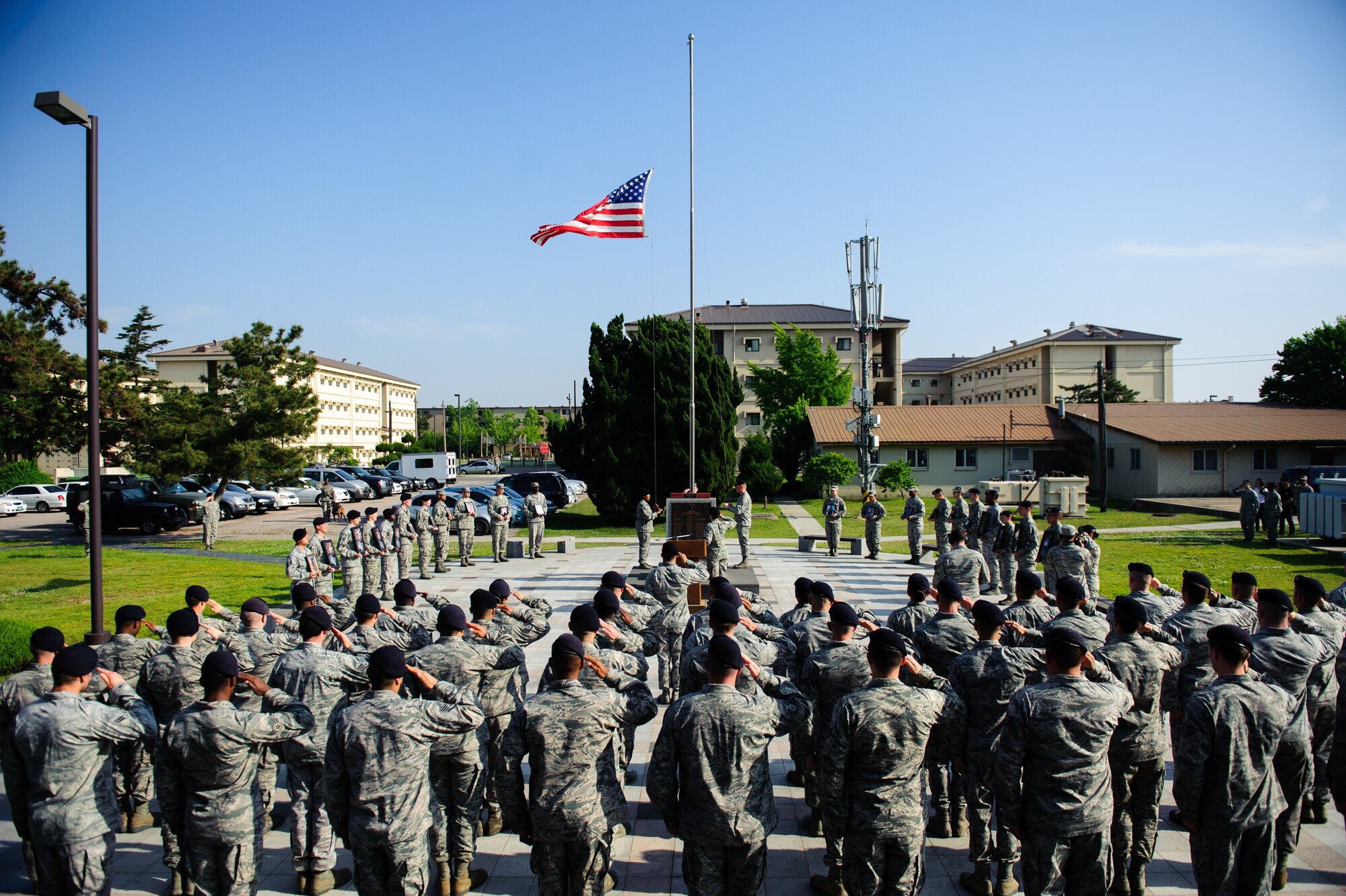 Airmen from the 8th Security Forces Squadron salute as the flag is lowered during a retreat ceremony at Kunsan Air Base, Republic of Korea, May 15, 2014. The 8th SFS honored 22 fallen defenders, office of special investigations agents and military working dogs as part of National Police Week. (U.S. Air Force photo by Senior Airman Armando A. Schwier-Morales/Released) 