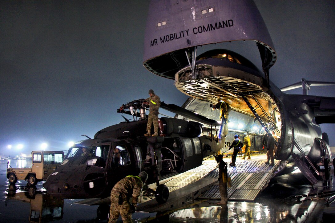 U.S. soldiers and airmen offload a UH-60 Black Hawk helicopter from a C-5 Galaxy aircraft on Bagram Airfield, Afghanistan, Feb. 2, 2013.  
