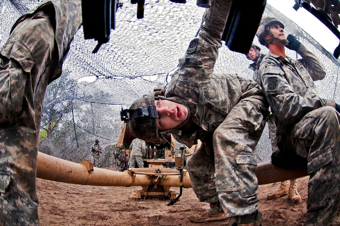 Army Spc. Michael Davis, center, checks the breech of an M119A2 105mm lightweight howitzer during a live-fire exercise on Fort Bragg, N.C., Jan. 16, 2013. Davis, an artilleryman, is assigned to the 82nd Airborne Division’s 3rd Battalion, 319th Airborne Field Artillery Regiment, 1st Brigade Combat Team.  
