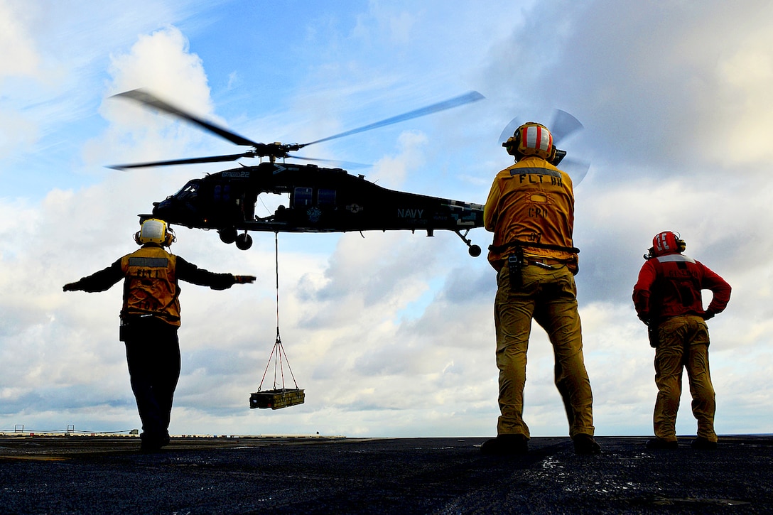 U.S. sailors prepare to receive an ordnance delivery from a Navy MH-60S Knighthawk helicopter on the flight deck of the aircraft carrier the USS George H.W. Bush as it conducted carrier qualifications in the Atlantic Ocean, Jan. 15, 2013. The Knighthawk is assigned to Helicopter Sea Combat Squadron 22. U.S.  
