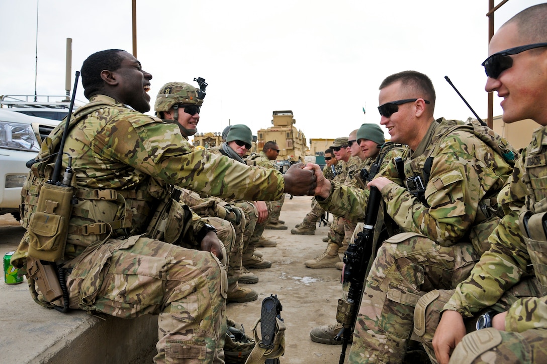 U.S. Army Pfc. Lorne Coleman, left, and Sgt. Jason Klawuhn, right, share a laugh while hanging out before a mission to visit the provincial director of agriculture, irrigation and livestock in Farah City, Afghanistan, Jan. 8, 2013. Members of Provincial Reconstruction Team Farah traveled to the area to evaluate progress on a demonstration greenhouse project to connect Farah farmers with government representatives.  
