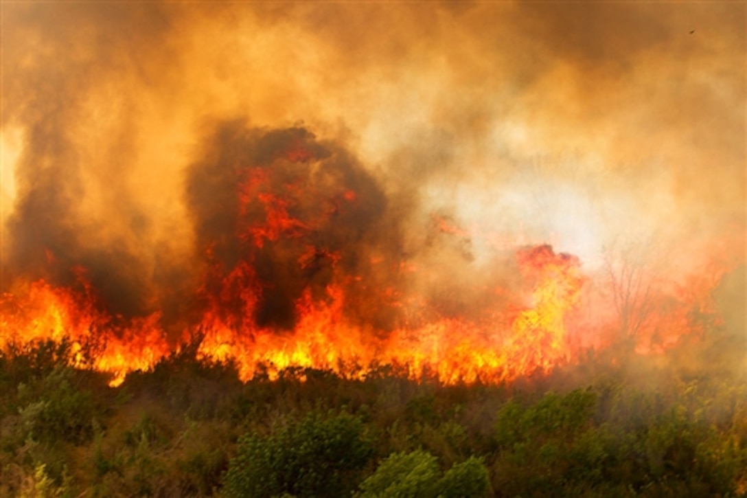 A photo shows the Tomahawk wildfires burning across Marine Corps Base Camp Pendleton, Calif., May 16, 2014. The Marine Medium Helicopter Squadron 364, Marine Aircraft Group 39, 3rd Marine Aircraft Wing, and Camp Pendleton Fire Department worked with state officials to prevent fires from spreading off base.  