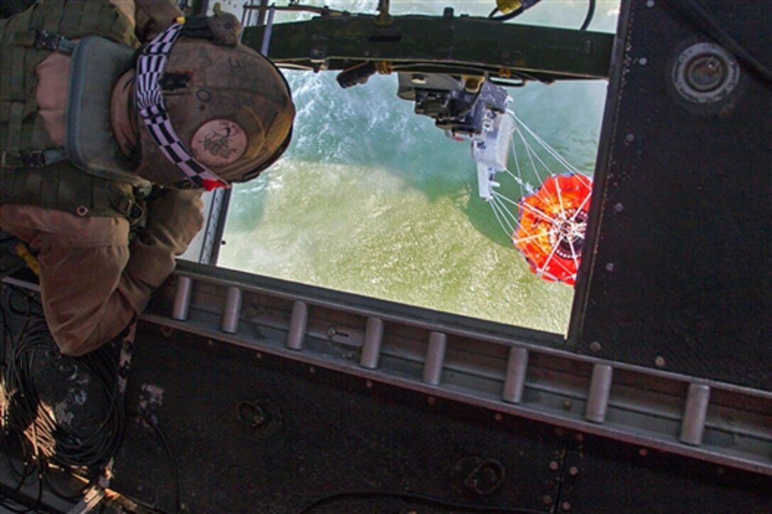 U.S. Marine Corps Sgt. Carmen Zangari observes a Bambi bucket being filled beneath a CH-46 Sea Knight helicopter to help fight the Tomahawk wildfires burning across Marine Corps Base Camp Pendleton, Calif., May 16, 2014. Zangari, a flightline crew chief, is assigned to Marine Medium Helicopter Squadron 364, Marine Aircraft Group 39, 3rd Marine Aircraft Wing.  