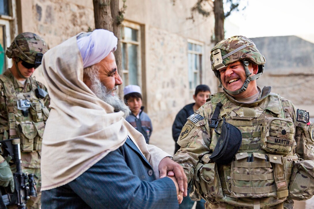 U.S. Army Lt. Col. Mark Martin, right, shakes hands and laughs with Mawlawi Guhlam M. Ruhaani, director of Hajj and Endowment, at the end of a meeting with key leaders in Farah City, Afghanistan, Dec. 29, 2012. Martin is a civil affairs team lead for Provincial Reconstruction Team Farah, which trains, advises and assists Afghan government leaders at the municipal, district and provincial levels in Farah province.  
