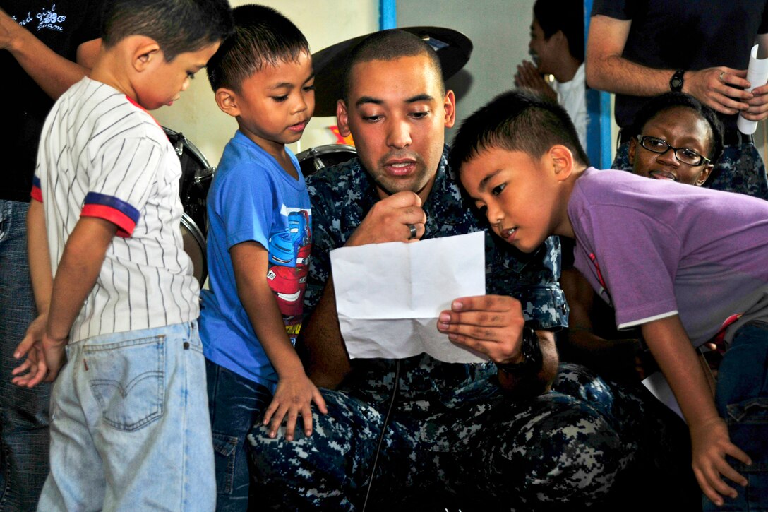U.S. Navy Seaman Brian Carrasquillo reads a holiday poem while participating in a community service event at Niños Pag Asa orphanage in Old Cabalan, Philippines, Dec. 24, 2012. U.S. sailors and faculty decorated the center, which cares for children with special needs and disabilities. Carrasquillo is assigned to the Emory S. Land, which is undergoing a voyage repair period in Subic Bay during an extended deployment.  
