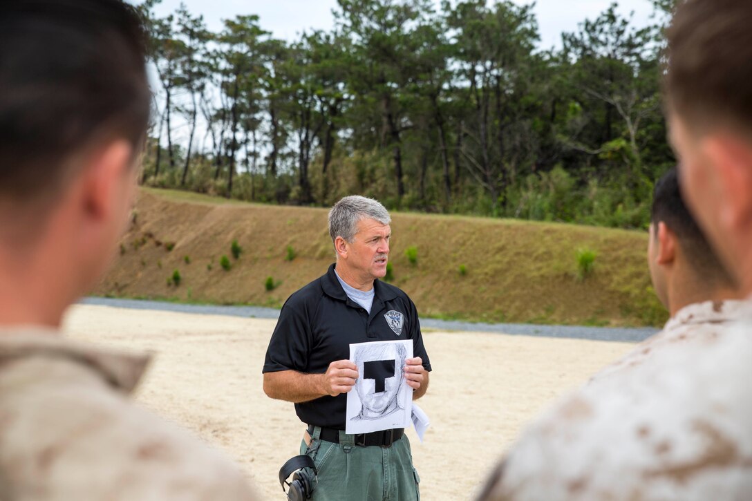 Ray Geller shows Marines the location on a target to place their shot May16 in the Central Training Area as part of a two-week Headquarters Marine Corps Special Reaction Team Phase II Marksman/Observer course. The course concluded with a one-shot, cold-bore marksmanship qualification in which the students fired an M110 semi-automatic sniper system. The culminating event was a pass-or-fail qualification with no second chance and no practice rounds. Geller is an advanced training group instructor with the Marine Corps Police Academy, Marine Corps Installation Law Enforcement, Security Division, Headquarters Marine Corps. The course brought together Marines with various units across multiple military occupational specialties assigned to III Marine Expeditionary Force and Marine Corps Installations Pacific. (U.S. Marine Corps photo by Cpl. Adam B. Miller/Released)