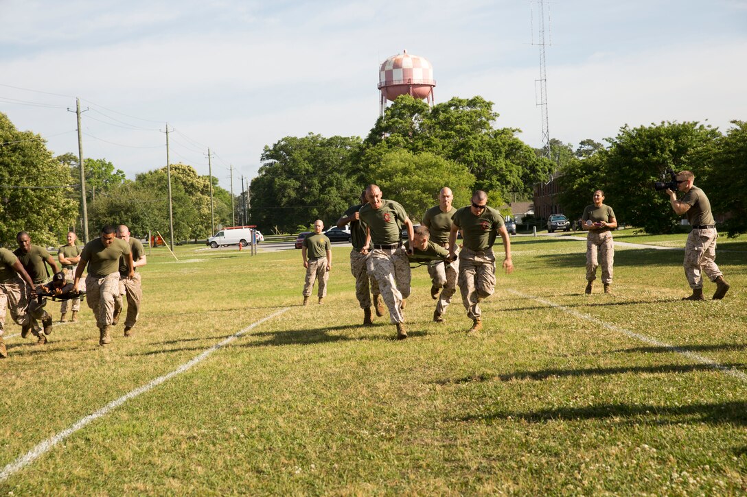 Marines participate in the litter relay event at a field meet held by Headquarters Support Battalion for the units’ monthly Commander’s Cup Challenge, aboard Marine Corps Base Camp Lejeune, May 15. The litter relay was one of nine events held during the field meet. The Commander’s Cup Challenge is a yearlong series of physical competitions where the battalion’s companies build teams to battle it out for fun and a chance to be the top company in the battalion.