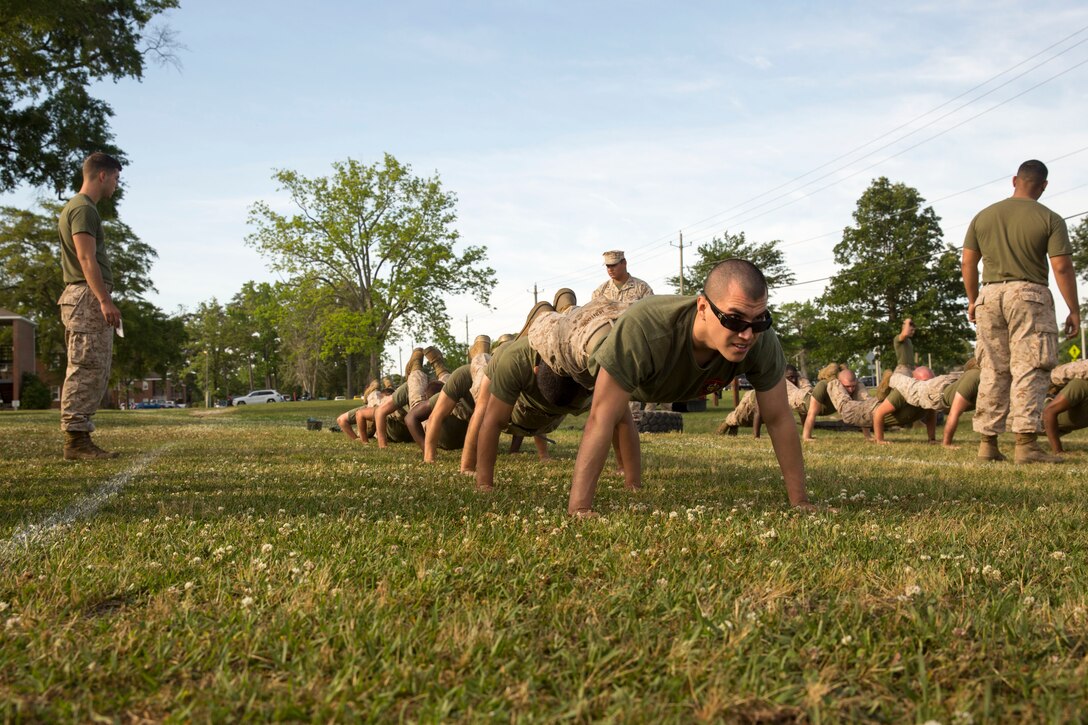 Lance Cpl. Louis Huntoon, a clerk with Alpha Company,, leads the way in Alpha Company’s squad pushup during the Super Squad event at HQSPTBn’s Commanders Cup Challenge field meet aboard Marine Corps Base Camp Lejeune, May 15. The Super Squad was considered the toughest event of the competition. 