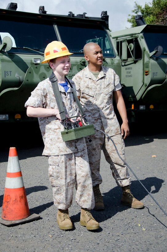 Sgt. Jelix Tarlac, wrecker chief with the Transport Services Company, Combat Logistics Battalion 3, shows Jared Kula how to use a crane at CLB-3’s workspaces, May 14, 2014. The 13-year-old, who has ulcerative colitis, wished to come to Hawaii to visit Pearl Harbor. Make-A-Wish Greater Pennsylvania and West Virginia granted his wish, and through coordination between Make-A-Wish Hawaii and Marine Corps Base Hawaii, Kula also spent a day with CLB-3 doing activities and touring Marine Corps Base Hawaii as an honorary “Marine for a Day.” (U.S. Marine Corps photo by Kristen Wong)
