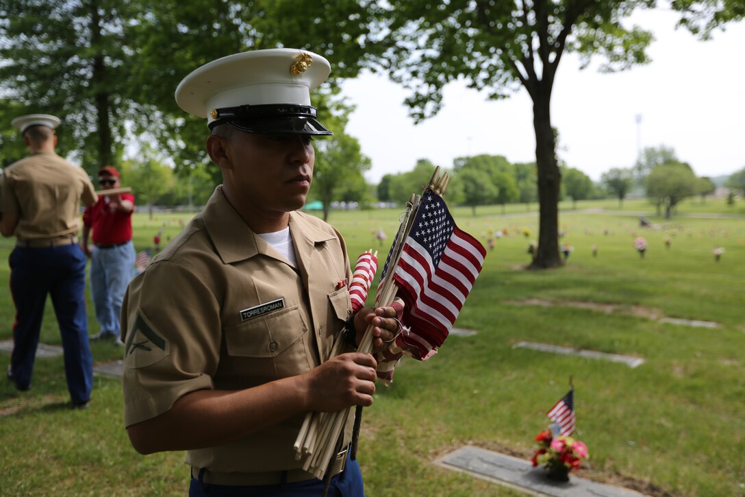 Lance Cpl. Edgar Torres-Roman with the 9th Marine Corps District carries American Flags to members of the Simpson Hoggat Marine Corps League to be placed on graves of passed veterans at Mount Moriah South Cemetery, May 21. (U.S. Marine Corps photo by Sgt. Andres J. Lugo)
