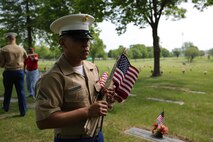 Lance Cpl. Edgar Torres-Roman with the 9th Marine Corps District carries American Flags to members of the Simpson Hoggat Marine Corps League to be placed on graves of passed veterans at Mount Moriah South Cemetery, May 21. (U.S. Marine Corps photo by Sgt. Andres J. Lugo)
