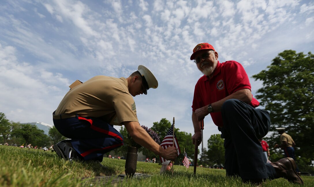 Sgt. Cameron Fidler with 9th Marine Corps District and a member of the Simpson Hoggat Marine Corps League detachment place an American flag on a grave of a veteran at Mount Moriah South Cemetery, May 21. (U.S. Marine Corps photo by Sgt. Andres J. Lugo)
