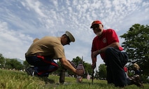 Sgt. Cameron Fidler with 9th Marine Corps District and a member of the Simpson Hoggat Marine Corps League detachment place an American flag on a grave of a veteran at Mount Moriah South Cemetery, May 21. (U.S. Marine Corps photo by Sgt. Andres J. Lugo)
