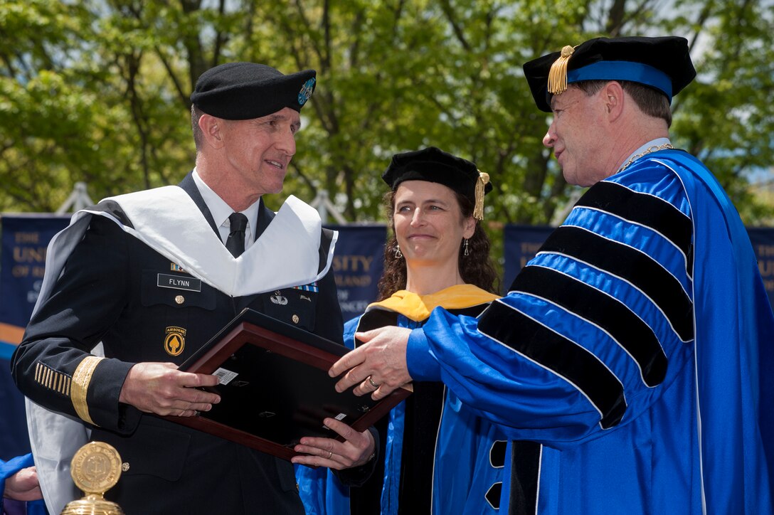 DIA Director Lt. Gen. Michael Flynn accepts an honorary doctorate of humane letters from University of Rhode Island President David Dooley May 18. Lisa DiPippo, URI professor of computer science, looks on. 
