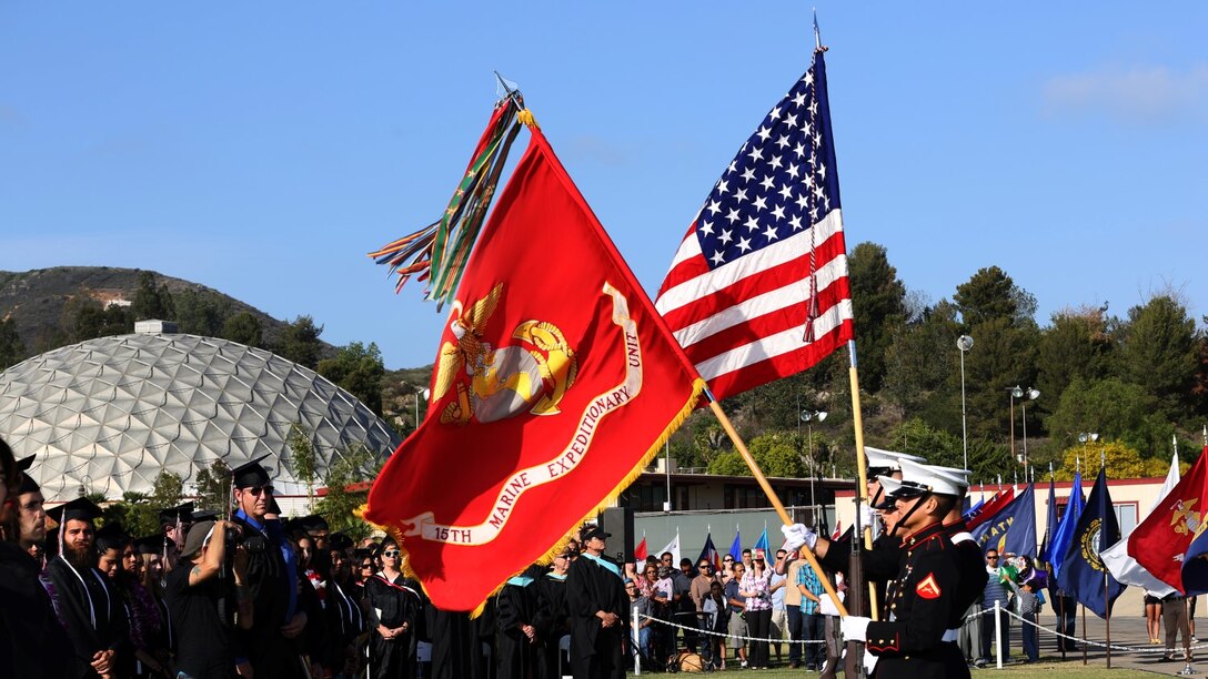 Corporal Justin G. Rush, embarkation specialist, 15th Marine Expeditionary Unit, presents the Organizational Colors during a commencement ceremony at Palomar College campus in San Marcos, Calif., May 20, 2014. Rush, 20, is from Tacoma, Wash. (U.S. Marine Corps photo by Cpl. Emmanuel Ramos/Released)
