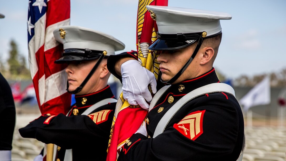 Corporal Justin G. Rush, right, embarkation specialist, 15th Marine Expeditionary Unit, adjusts the Colors during a commencement ceremony at Palomar College campus in San Marcos, Calif., May 20, 2014. Rush, 20, is from Tacoma, Wash. (U.S. Marine Corps photo by Lance Cpl. Anna Albrecht/Released)