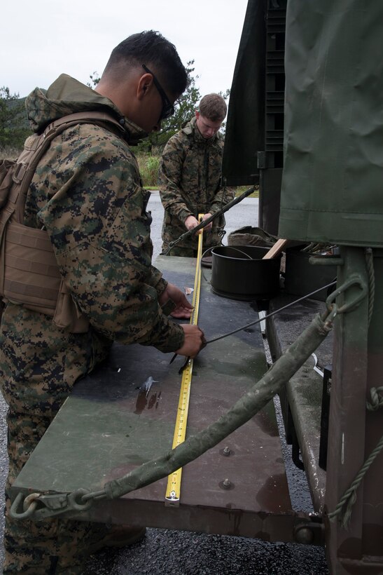 Sgt. Geovanny Ruiz, left, measures and cuts detonation cord to build explosive charges during training May 13 in the Central Training Area. The training covered basic demolitions and urban breaching, and taught the Marines how to build and place a variety of explosives. Ruiz is a combat engineer with Combat Engineer Company, Combat Assault Battalion, 3rd Marine Division, III Marine Expeditionary Force. (U.S. Marine Corps photo by Sgt. Jose O. Nava/Released)