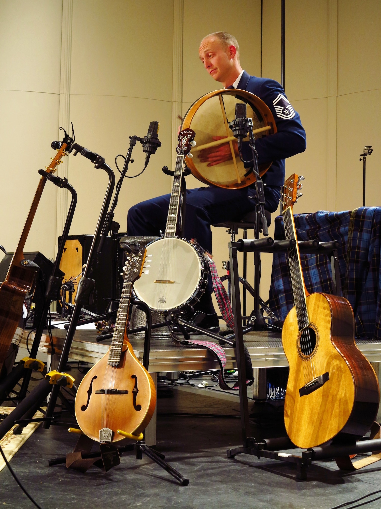 Senior Master Sgt. Dennis Hoffman plays the bodhran, surrounded by several stringed instruments.  Hoffman plays percussion, accordion, and even joins in the vocal harmonies. All members of Celtic Aire are versatile vocalists and instrumentalists. (U.S. Air Force photo by Technical Sgt. Mandi Harper/released)  