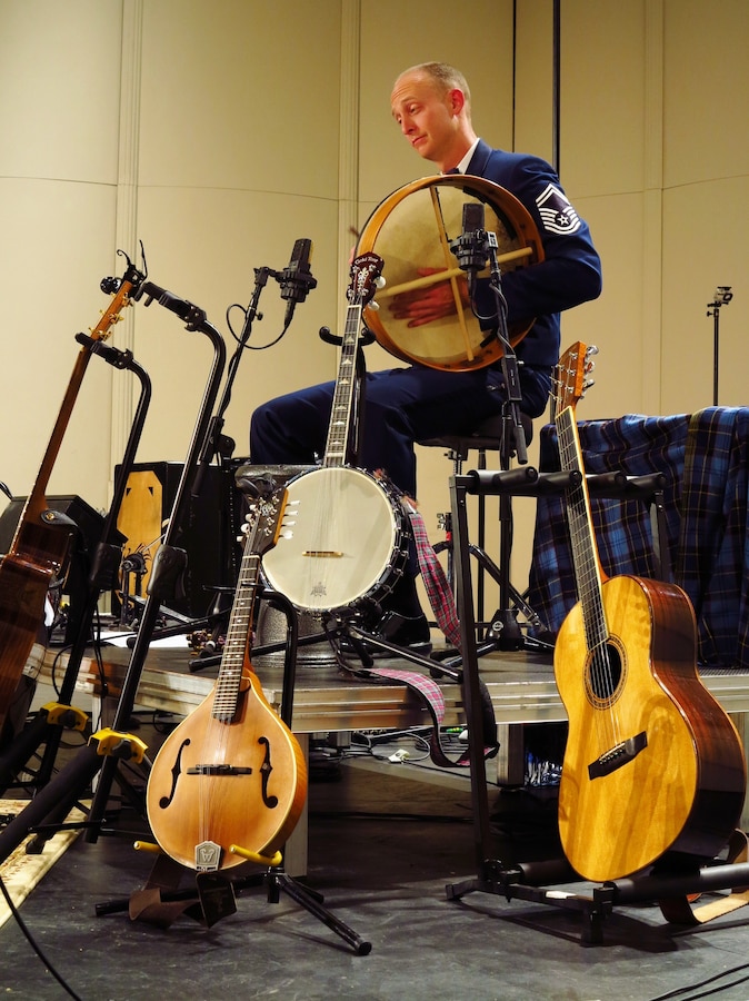 Senior Master Sgt. Dennis Hoffman plays the bodhran, surrounded by several stringed instruments.  Hoffman plays percussion, accordion, and even joins in the vocal harmonies. All members of Celtic Aire are versatile vocalists and instrumentalists. (U.S. Air Force photo by Technical Sgt. Mandi Harper/released)  