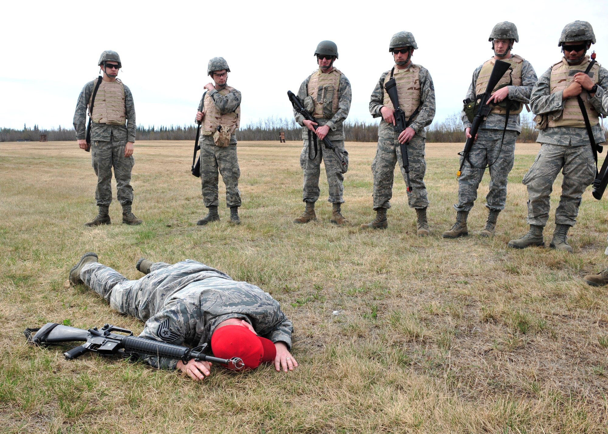 Tech. Sgt. Seth Stinnett, 354th Security Forces Squadron combat arms instructor, demonstrates how to low crawl to members of the 354th Civil Engineer Squadron May 15, 2014, Eielson Air Force Base, Alaska. 354th SFS instructors trained 354th CES members in different movement techniques applicable to deployments. (U.S. Air Force photo by Senior Airman Ashley Nicole Taylor/Released)