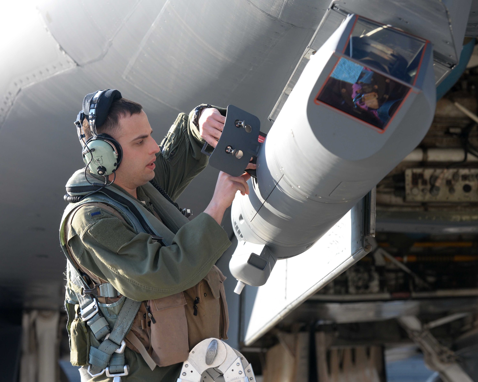 First Lt. Brian Combes, 34th Bomb Squadron B-1 offensive systems officer, loads software into a sniper advanced targeting pod on a B-1B Lancer prior to a Global Power Mission at Ellsworth Air Force Base, S.D., May 12, 2014. The long-range targeting system provides aircrews with positive target identification, autonomous tracking coordinate generation and precise weapons guidance from extended standoff ranges supporting air to ground operations.(U.S. Air Force photo by Airman 1st Class Rebecca Imwalle/Released)