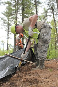 140521-Z-VA676-069 -- Senior Airman Gydeon Burgess works on constructing an erosion control fence at Camp Hinds Boy Scout Camp, Raymond, Maine, May 21, 2014. Senior Airman Jason Armstrong is in the background. The Airmen are members of the 127th Civil Engineer Squadron, based at Selfridge Air National Guard Base, Mich. The Airmen, along with Marine Corps Reservists and Army Reservists, are working on various construction projects at the camp during an Innovative Readiness Training mission, which allows military personnel to get training in various tasks and a community organization, in this case the Boy Scouts, to benefit from the work. (U.S. Air National Guard photo by Technical Sgt. Dan Heaton)