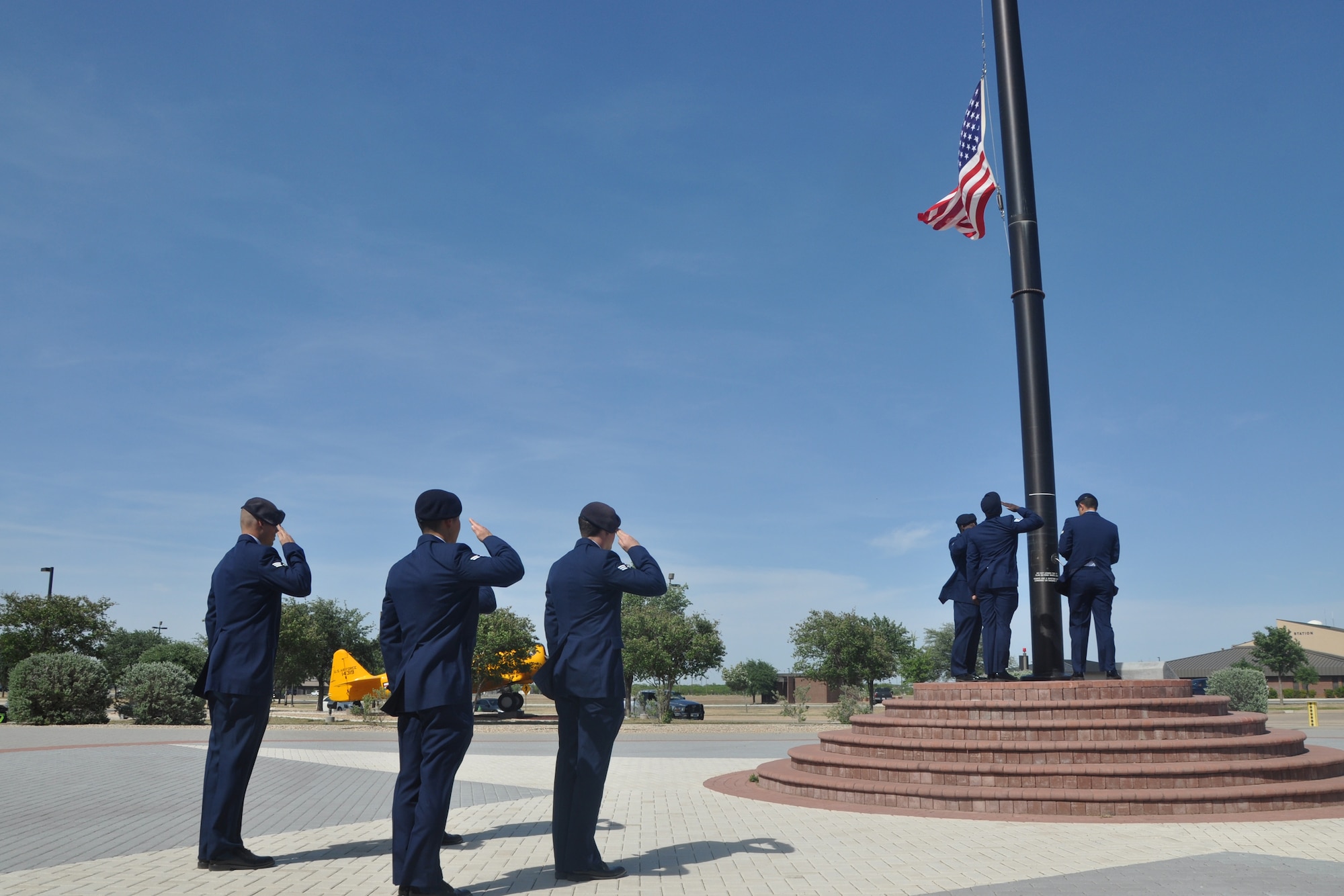 GOODFELLOW AIR FORCE BASE, Texas – Airmen from the 17th Security Forces Squadron salute the flag as it’s being lowered during the Retreat Ceremony at the Norma Brown Building here May 16. During the ceremony, the flag was folded and Taps was played.  (U.S. Air Force photo/ Airman 1st Class Breonna Veal)  