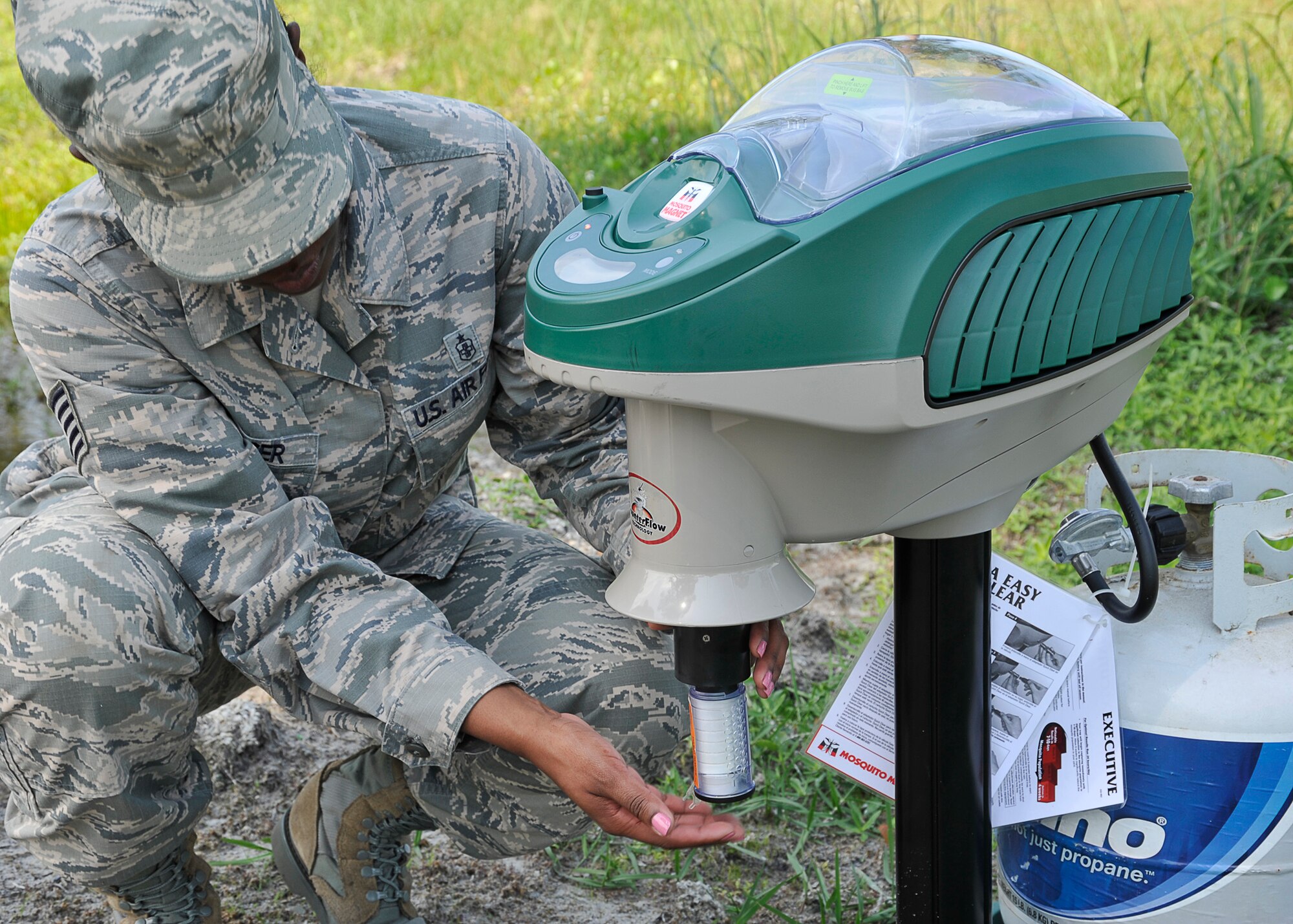 Tech. Sgt. Tanisha Spencer, 325th Aerospace Medical Squadron NCO in charge of community health, prepares a mosquito trap May 20 at the base track. After mosquitoes are identified and tested, 325th ADMS then calls the 325th Civil Engineering Squadron to keep the mosquito population down. (U.S. Air Force photo by Airman 1st Class Solomon Cook)