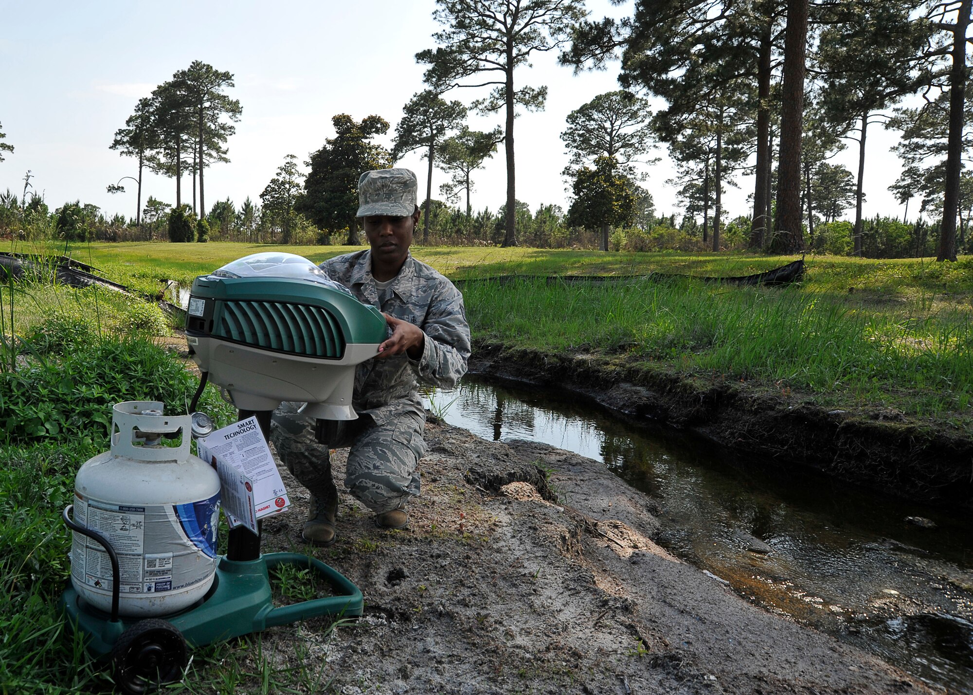 Tech. Sgt. Tanisha Spencer, 325th Aerospace Medical Squadron NCO in charge of community health, prepares a mosquito trap May 20 at the base track. Mosquito traps are left overnight to determine the population and species of mosquitoes in an area. (U.S. Air Force photo by Airman 1st Class Solomon Cook)