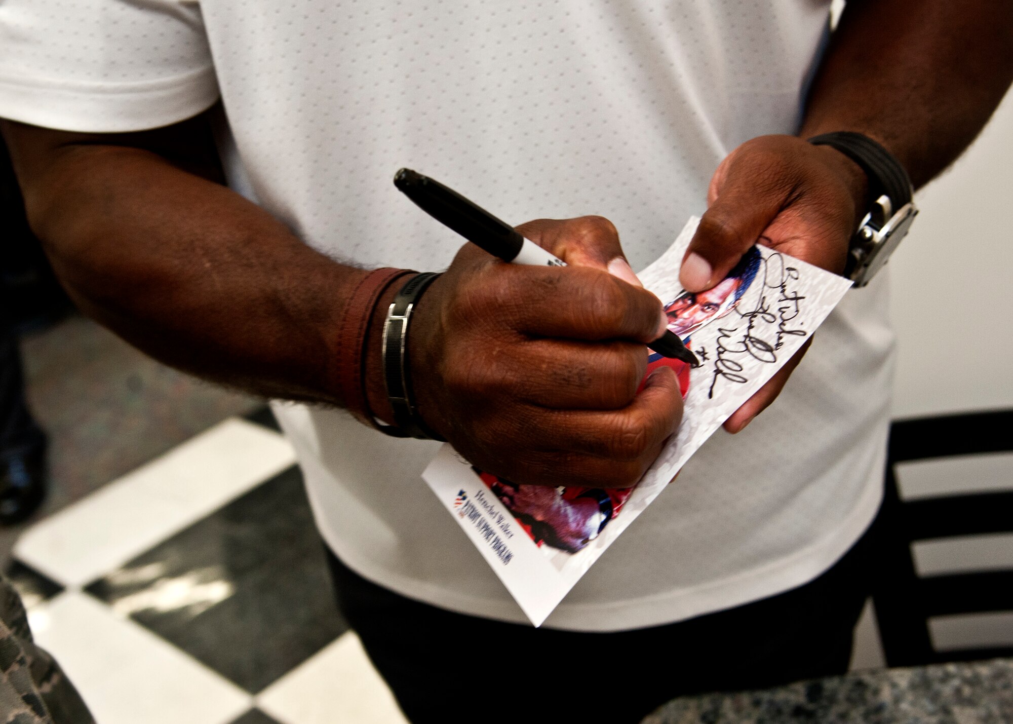 Herschel Walker signs an autograph after a breakfast May 21, 2014, at Whiteman Air Force Base, Missouri. Walker was inducted into the College Football Hall of Fame in 1999. (U.S. Air Force photo by Senior Airman Daniel Phelps/Released)