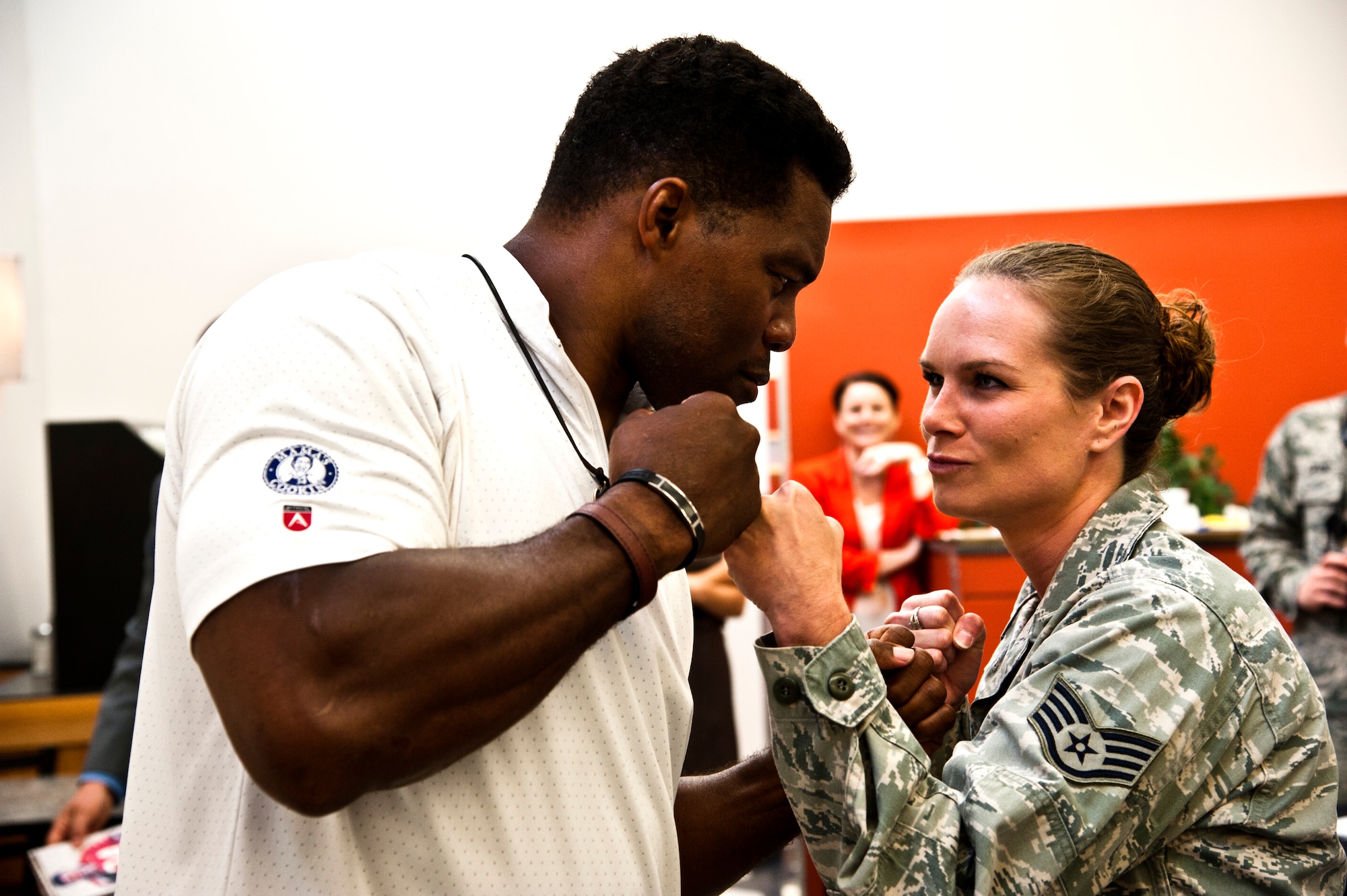 Herschel Walker and Staff Sgt. Sabrina Smith, 442nd Maintenance Group analyst, pose for a mixed martial arts style photo May 21, 2014, at Whiteman Air Force Base, Missouri. In addition to being an NFL star and a bob sled team Olympian, Walker has also been a professional MMA competitor. (U.S. Air Force photo by Senior Airman Daniel Phelps/Released)
