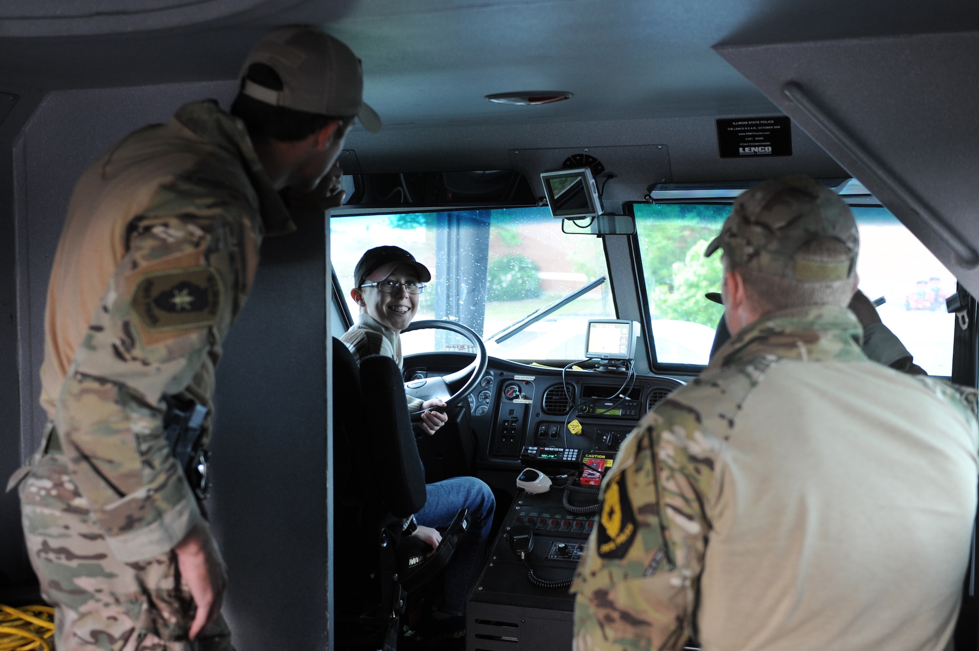Alex Bendele, 14, talks with Troopers Kyle Rensing and Matt Hannan, Illinois State Police SWAT team members, about their vehicle at Scott Air Force Base, Ill. on May 15, 2014. The 375th Security Forces Squadron teamed up with police from the surrounding community to educate the public about the purpose of the police and the equipment they employ. (U.S. Air Force photo by Senior Airman Sarah Hall-Kirchner/Released)