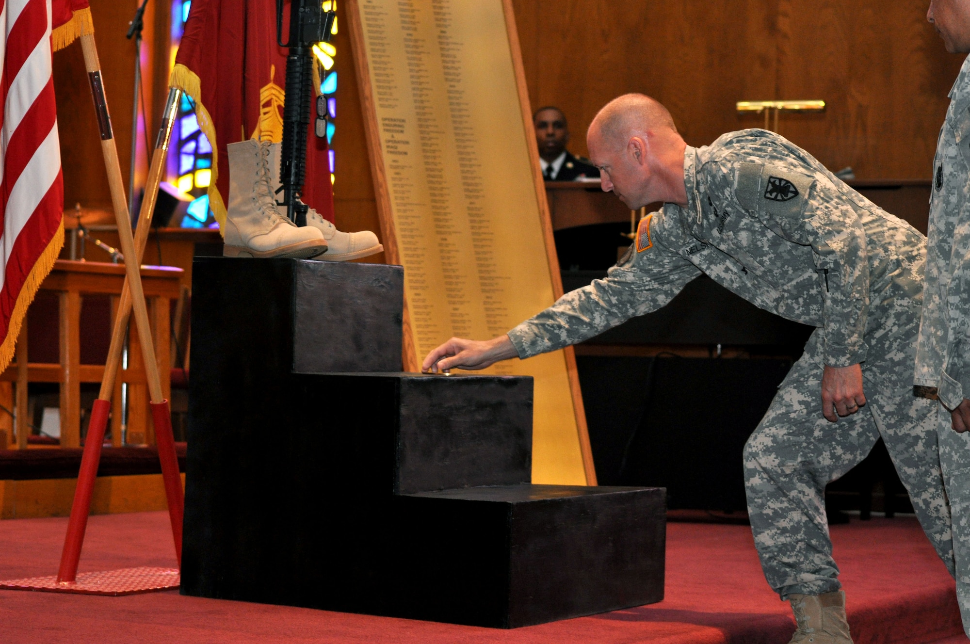 U.S. Army Col. Randal Nelson, 7th Transportation Brigade (Expeditionary) commander, lays a brigade coin down during the Transportation Corps Memorial Wall Rededication Ceremony at Fort Eustis, Va., May 21, 2014.  The rededication concluded with a ceremonial bell ringing as each of the 47 names added to the plaque were read aloud. Families, Soldiers and friends were able to render a final salute, paying tribute to the fallen Transportation Corps Soldiers. (U.S. Army photo by Sgt. Stefanie Warner/Released)