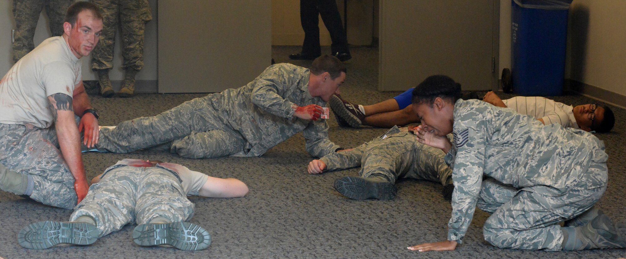 Several Airmen, portraying casualties during a training exercise at Robins Air Force Base, Ga., react to the carnage May 20, 2014. The active-shooter training exercise is conducted annually as required by the Air Force. (U.S. Air Force photo by Ray Crayton)