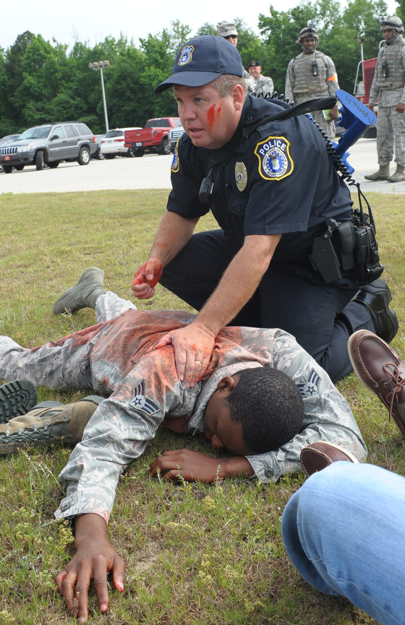 Mark Campbell, Department of the Air Force policeman, assesses casualties following a simulated mass shooting at Robins Air Force Base, Ga. The active-shooter training event is conducted annually. (U.S. Air Force photo by Ray Crayton)