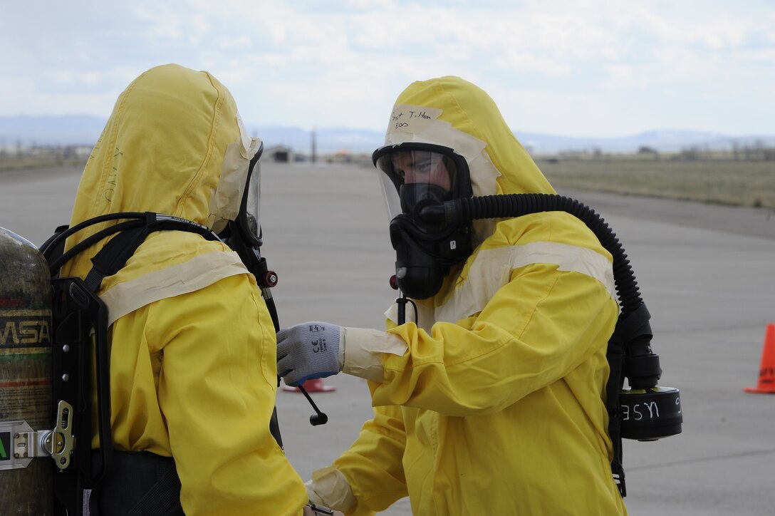 341st Civil Engineer Squadron Explosive Ordinance Disposal team members, check each other’s gear for tears before being decontaminated during exercise Constant Viligance at Malmstrom Air Force Base, Montana, May 13, 2014. During the simulation, Team Malmstrom members implemented their training to mitigate a potential disaster and practice for real life scenarios. (U.S. Air Force Photo/Airman 1st Class Collin Schmidt)