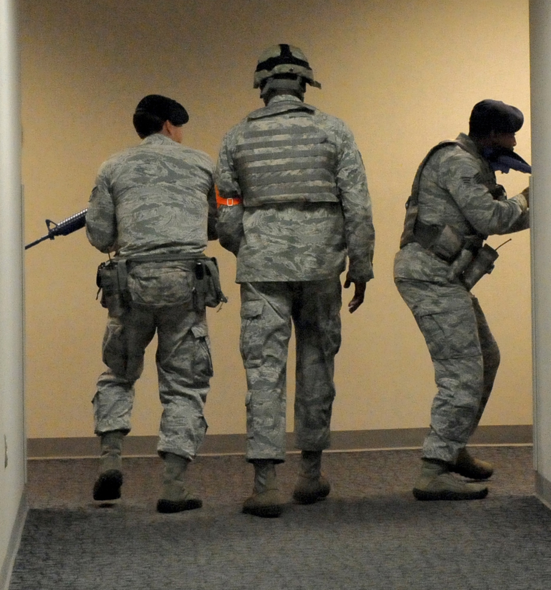 Two 78th Security Forces Squadron defenders, followed by an evaluator, make their way through a building May 20, 2014, during an active-shooter exercise at Robins Air Force Base, Ga. (U.S. Air Force photo by Ray Crayton)