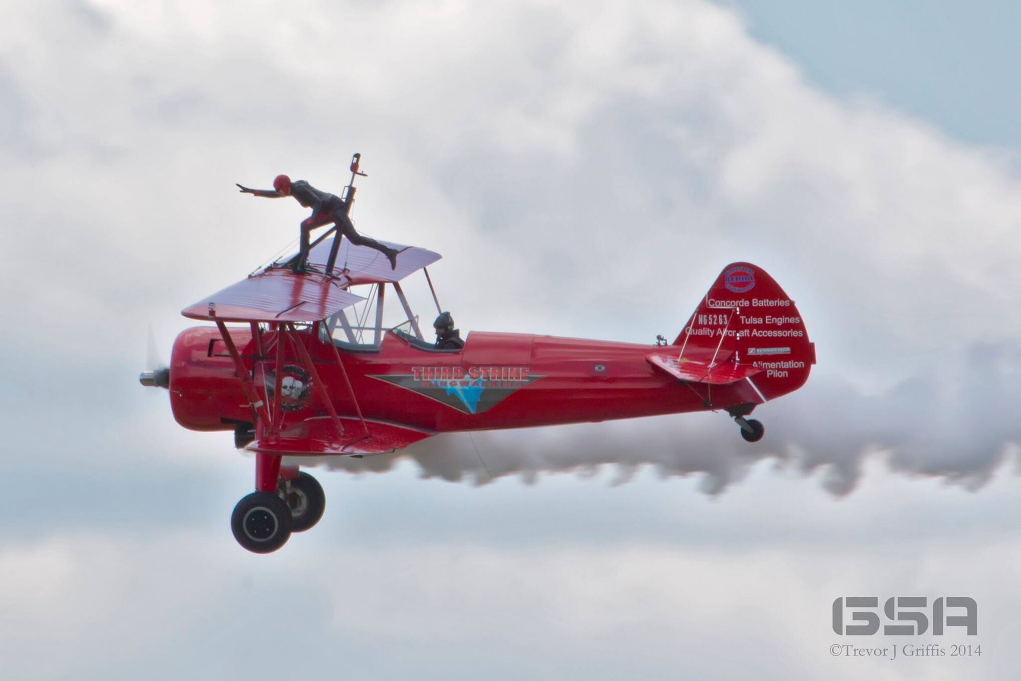 Carol Pilon strikes a pose on the wing of her 1940 Boeing-Stearman aircraft here, May 18, 2014. Pilon performed on the wings of the aircraft, piloted by Marcus Payne, as part of the 2014 Thunder Over the Valley Air Show and Open House, hosted here May 17-18. Pilon began wing-walking in 2001 and founded Third Strike Wingwalking in 2004 with the goal of inspiring young people to pursue aviation. Courtesy photo by Trevor Griffis/GSA Photography.