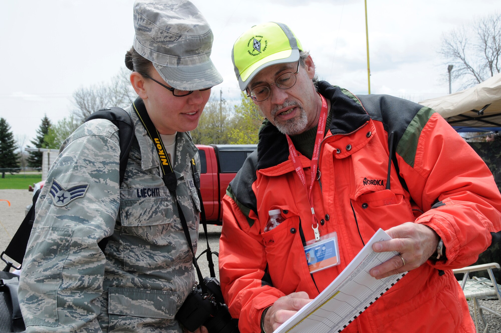 Air Force Senior Airman Andrea Liechti, a photojournalist with the 115th Fighter Wing of the Wisconsin Air National Guard, is briefed by Mr. John Maggitti, an ametuer radio operator participating in SIMCOM 2014 at Sunnyview Expo Center in Oshkosh, Wis. May 15, 2014. SIMCOM (State Interoperable Mobile Communications) is a functional exercise designed to test the interoperability of federal, state, county, tribal, volunteer, private organizations and defense communications and data sharing. Air National Guard photo by Tech. Sgt. Todd Pendleton (Released)